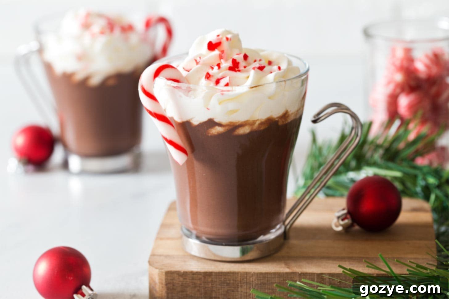 Two glasses of Peppermint hot cocoa served with candy canes