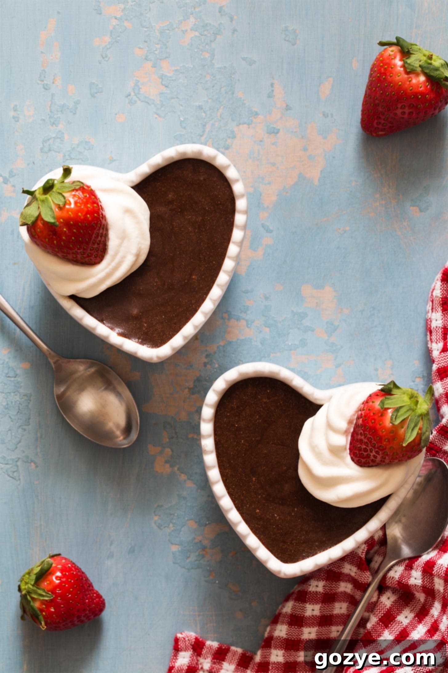 Homemade chocolate mousse served in heart-shaped ramekins with whipped cream