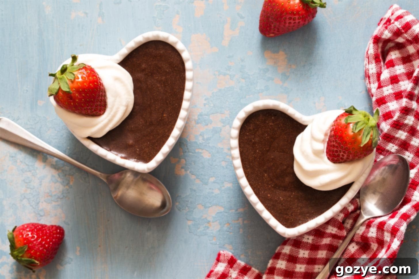 Chocolate mousse for two served in heart ramekins with a spoon