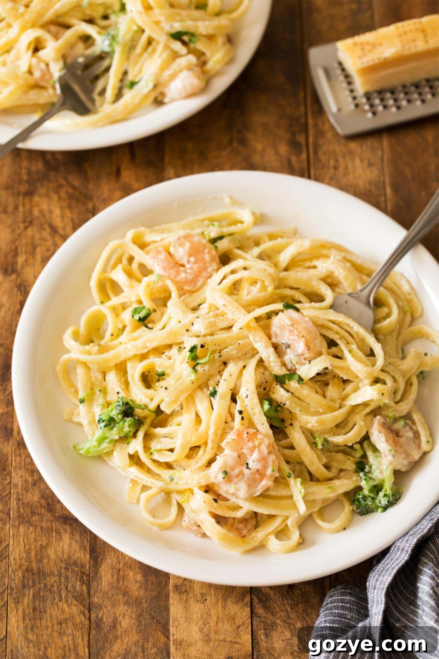 Shrimp Fettuccine Alfredo with broccoli served on white plate