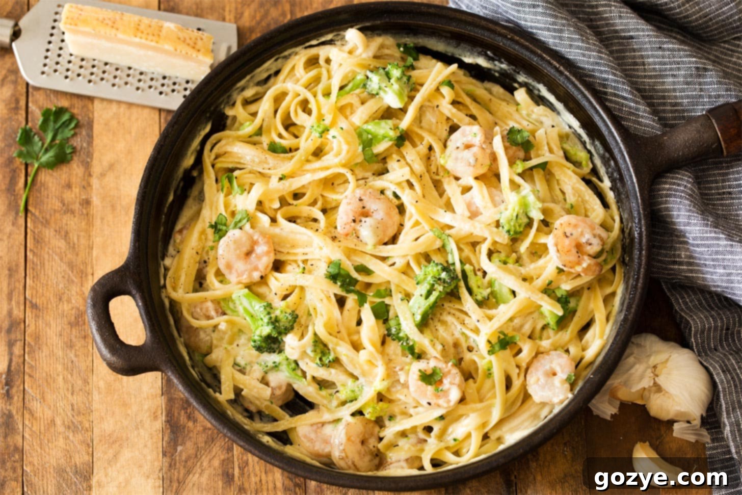 Fettuccine alfredo and shrimp with broccoli served from skillet
