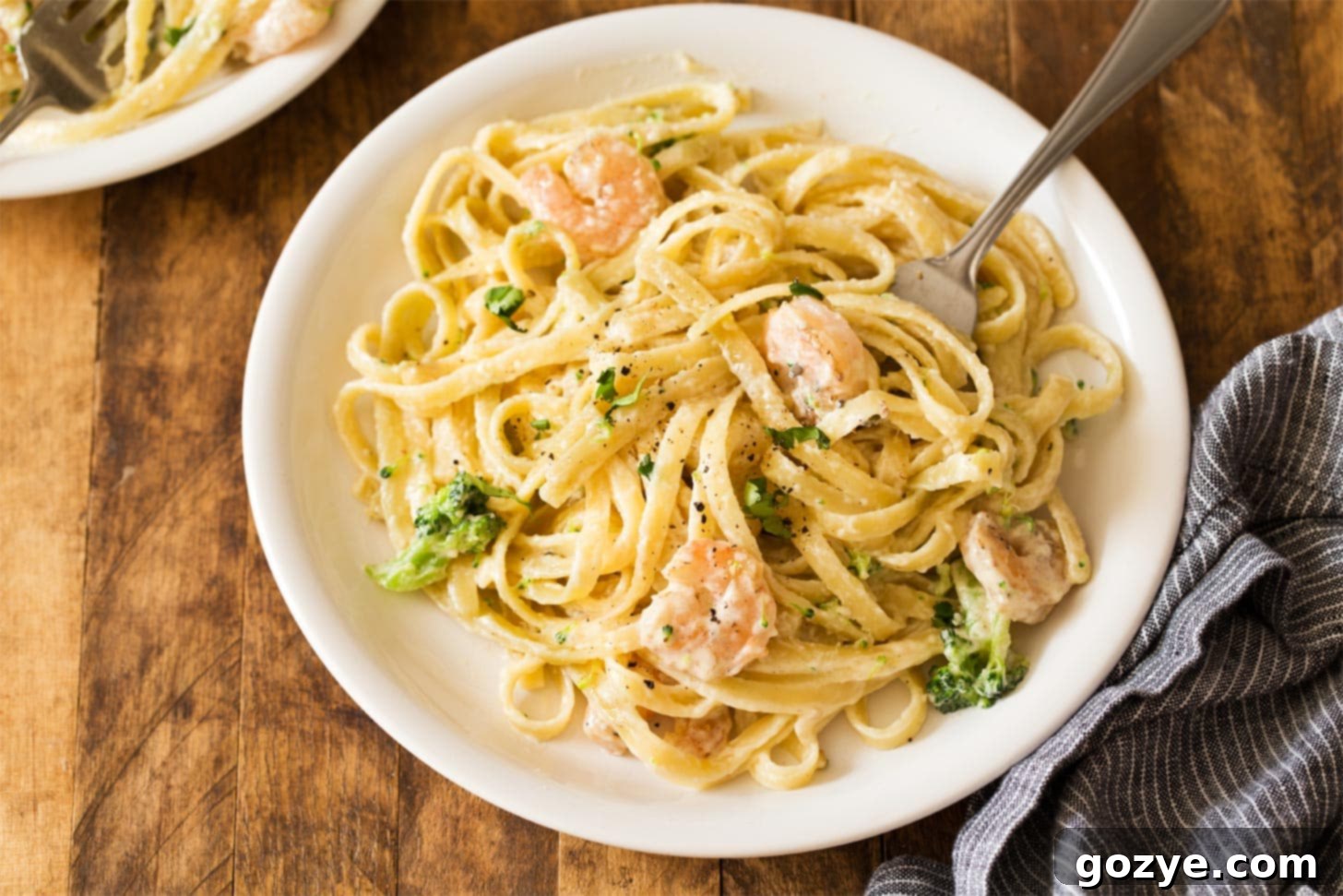 White plate with shrimp and broccoli aflredo