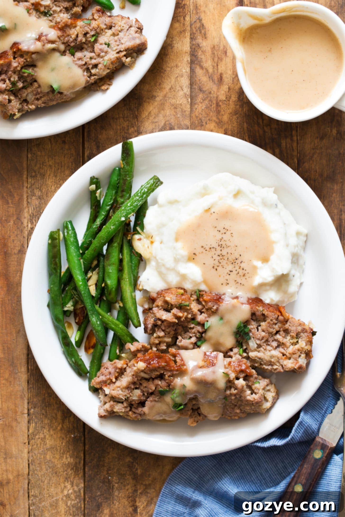 Small meatloaf recipe served with mashed potatoes, gravy, and green beans - a comforting dinner for two.