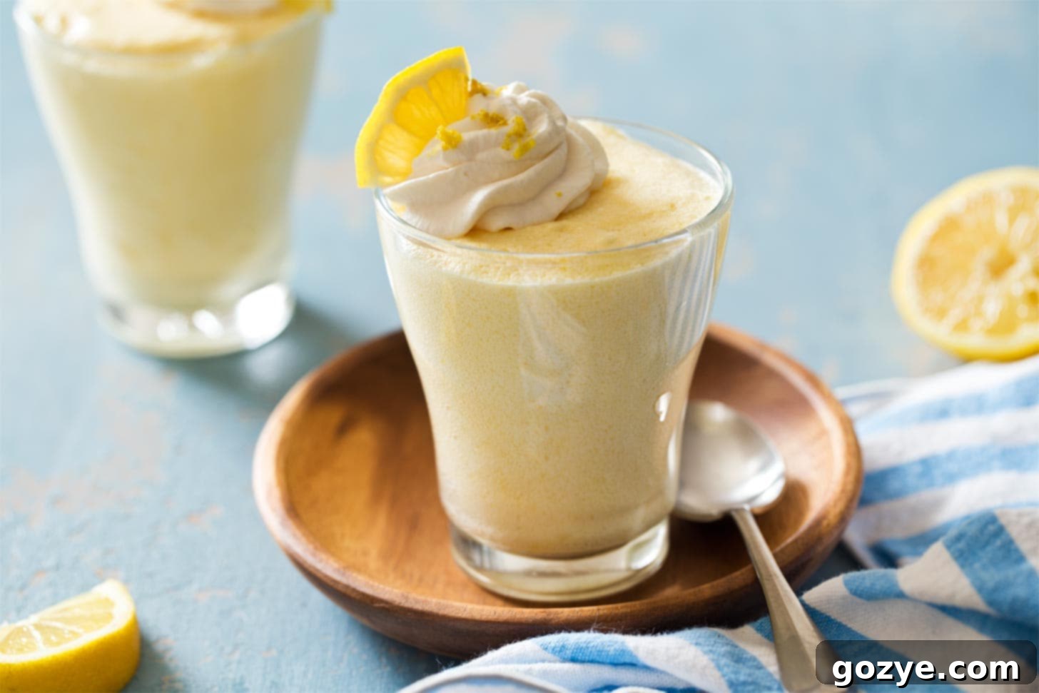 Lemon mousse in a cup on a wooden plate